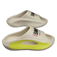 Cream-colored slide sandals with neon yellow accents.