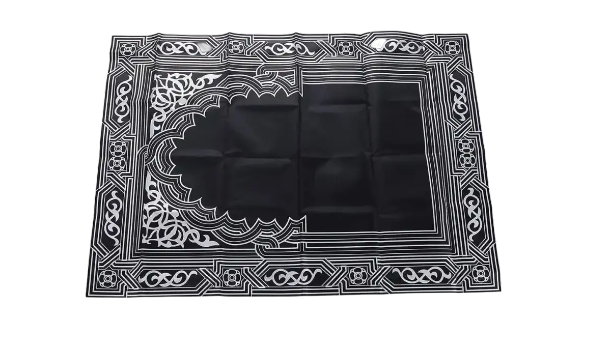 Black prayer mat with white geometric design.