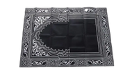 Black prayer mat with white geometric design.