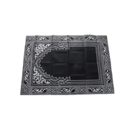 Black prayer mat with white geometric design.