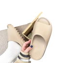 Beige Yeezy slide sandals.