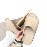 Beige Yeezy slide sandals.
