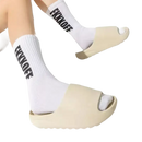 Beige slide sandals with white socks.