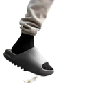 Gray slide sandals with black socks.