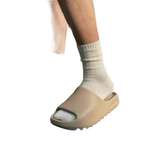 Tan-colored slide sandals with white socks.