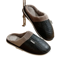 Black leather-look slippers with gray faux fur lining.