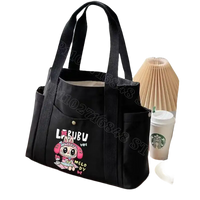 Black canvas tote bag with cartoon graphic.