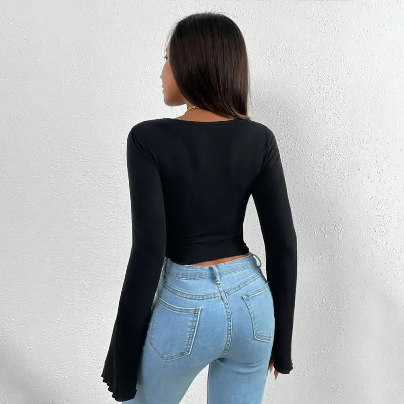Woman’s black long-sleeved top and blue jeans.