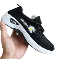 Black knit women’s sports shoes with white mesh soles and daisy detail