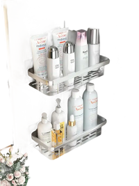 Two-tiered aluminum corner shelves filled with toiletries.