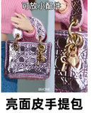 Shiny pink patterned handbag with gold charms.