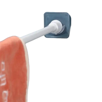 Adhesive towel bar with orange towel.