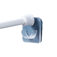 Clear adhesive curtain rod holder.