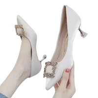 Elegant white high heels with jeweled buckle.
