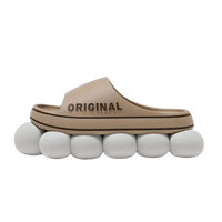 Beige slide sandal on white spheres.