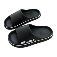 Black slide sandals with white trim.