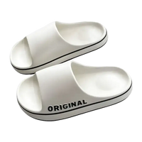 White slide sandals with black trim.