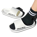 White slide sandals with black trim.