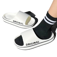 White slide sandals with black trim.
