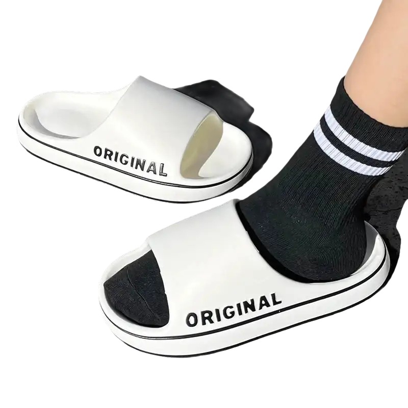White slide sandals with black trim.
