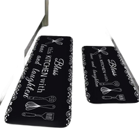 Black kitchen mats with white lettering and utensil designs.