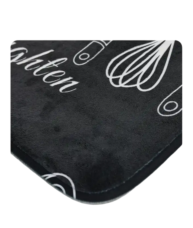 Black kitchen mat with white utensil designs.