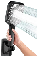 Black handheld shower head with water flowing.