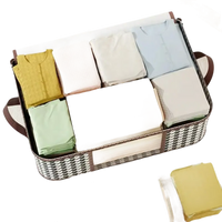 Fabric storage basket with folded clothes.