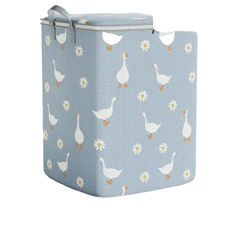 Blue laundry hamper with goose and daisy pattern.