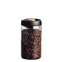 Coffee bean-filled glass jar with black lid.