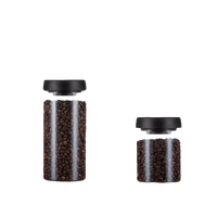 Two glass storage jars with black lids.