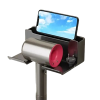 Wall-mounted hair dryer holder with phone slot.