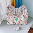 Patterned tote bag with gray straps.