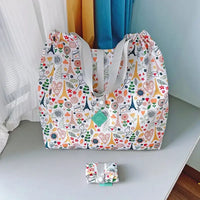 Patterned tote bag with gray straps.
