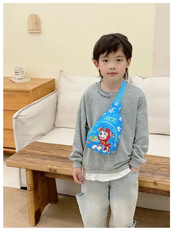Boy wearing a blue Paw Patrol sling bag.