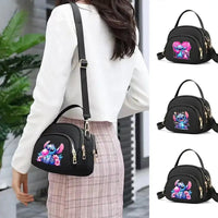 Black crossbody bag with cartoon character.