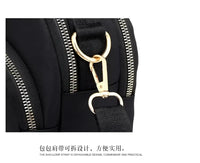 Black nylon bag with gold hardware.