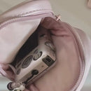 Pink bag containing a silver camera.