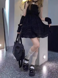 Black ruffled dress with arm warmers.
