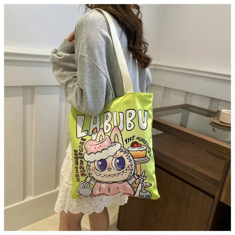 Green tote bag with cartoon monster.