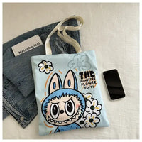 Light blue tote bag with cartoon monster.