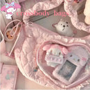 Pink quilted crossbody bag with heart-shaped window.