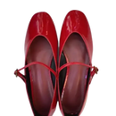 Pair of shiny red Mary Jane shoes.