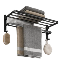 Black metal towel rack with towels and bath accessories.