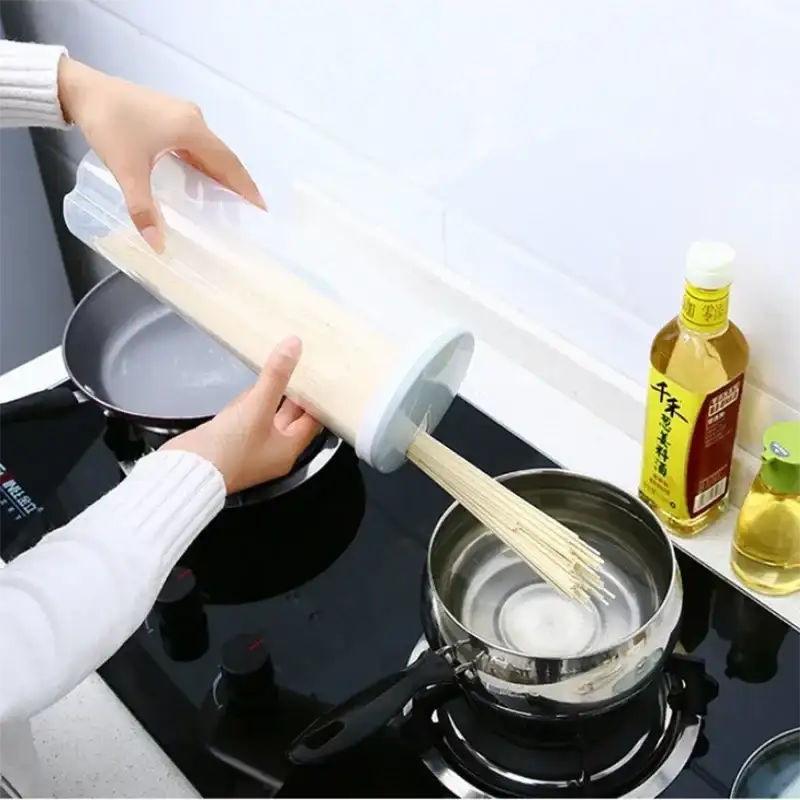 Spaghetti being poured from a plastic container into a pot.
