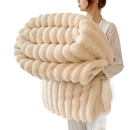 Cream-colored, plush, ribbed throw blanket.