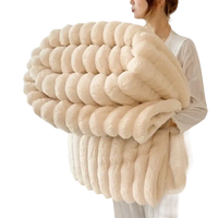 Cream-colored, plush, ribbed throw blanket.