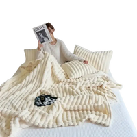 Cream-colored, textured plush blanket.