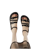 Black leather buckled sandals.