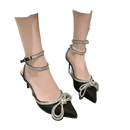 Black high heels with rhinestone bows and ankle straps.